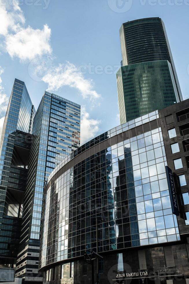 Detail blue glass building background with cloud sky photo