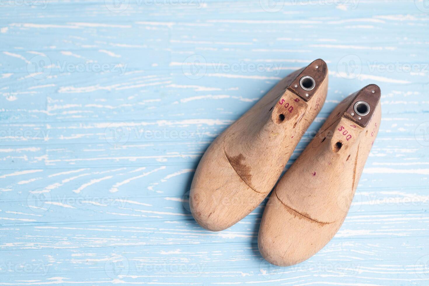 Leather samples for shoes and wooden shoe last on blue wooden table. photo