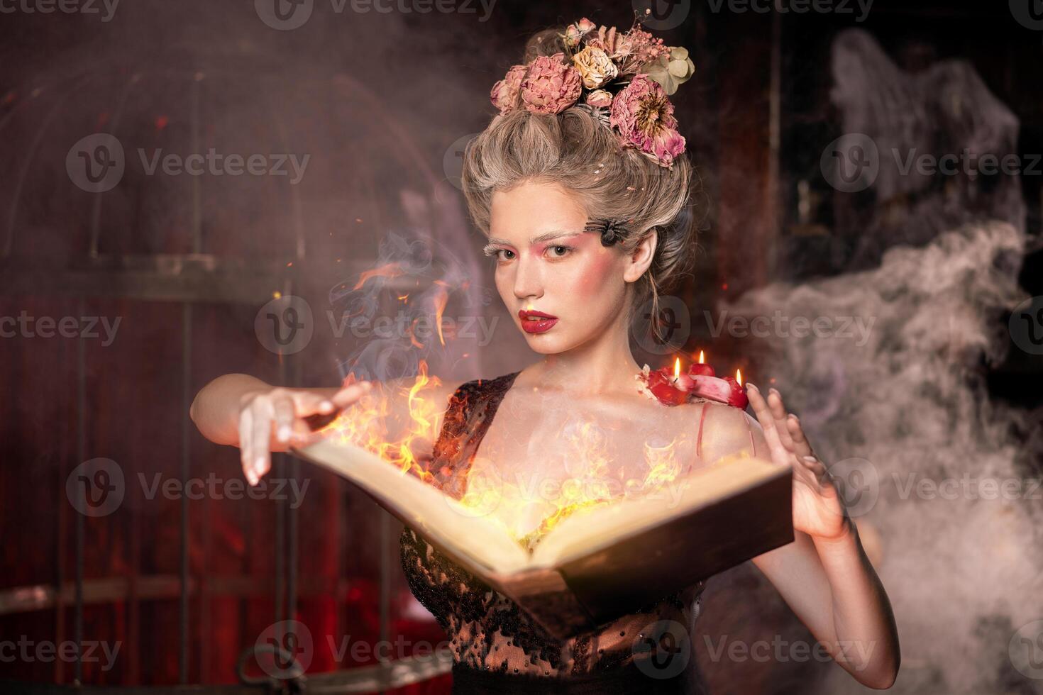 Charming woman witch flowers in hair vintage black dress with book of spell in the old castle. Halloween. Celebration. photo