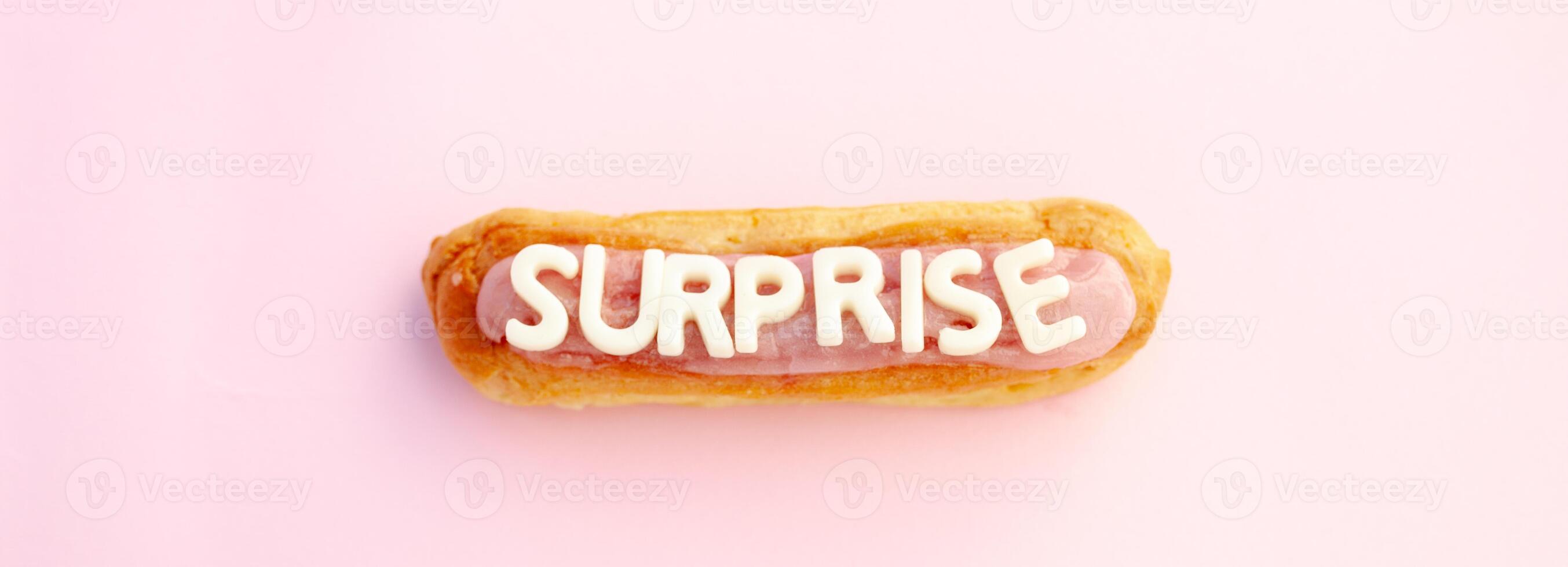 Surprise word written in eclair voluminous white letters on a beautiful pink background. photo