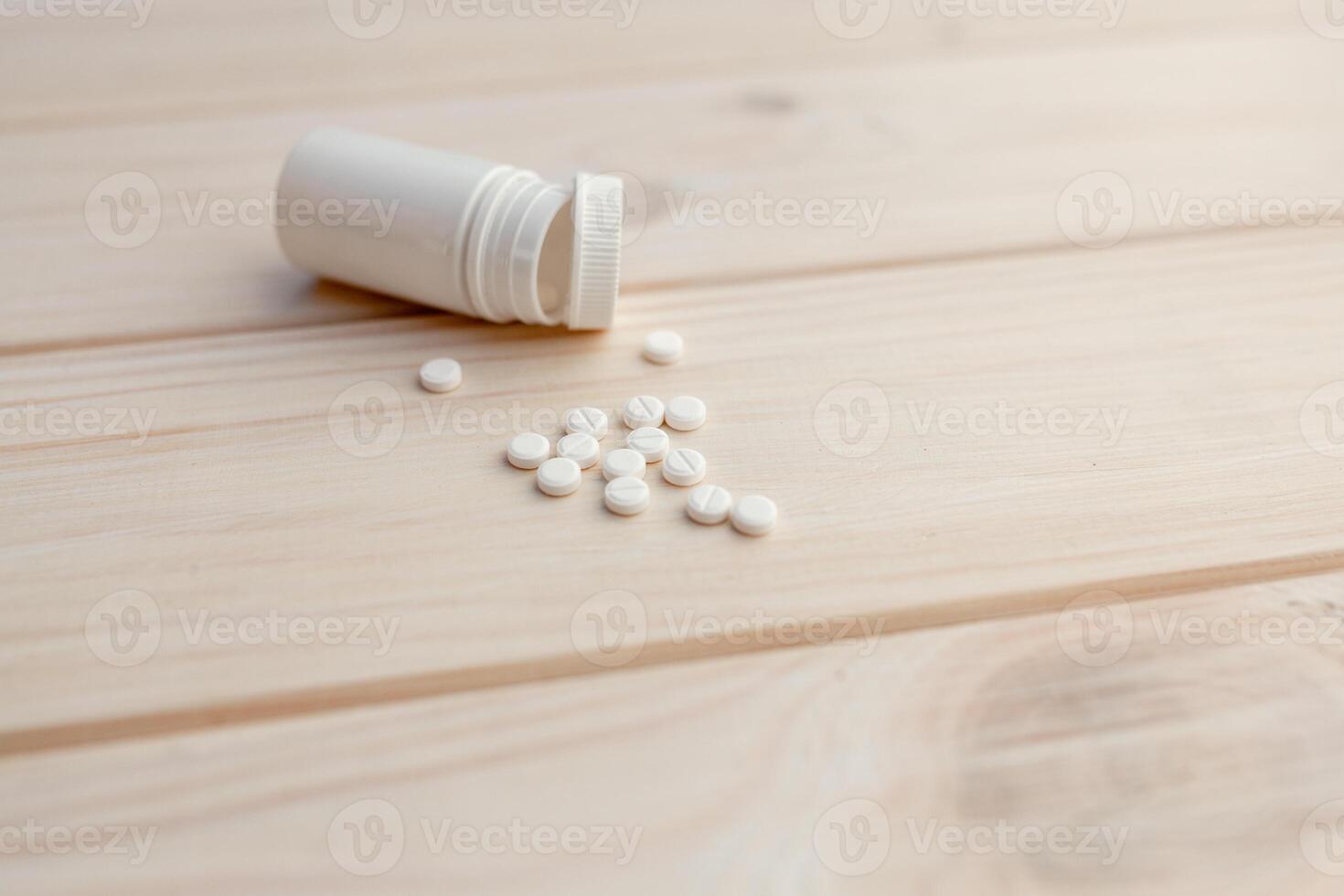 pastillas y píldora botella en blanco de madera antecedentes foto