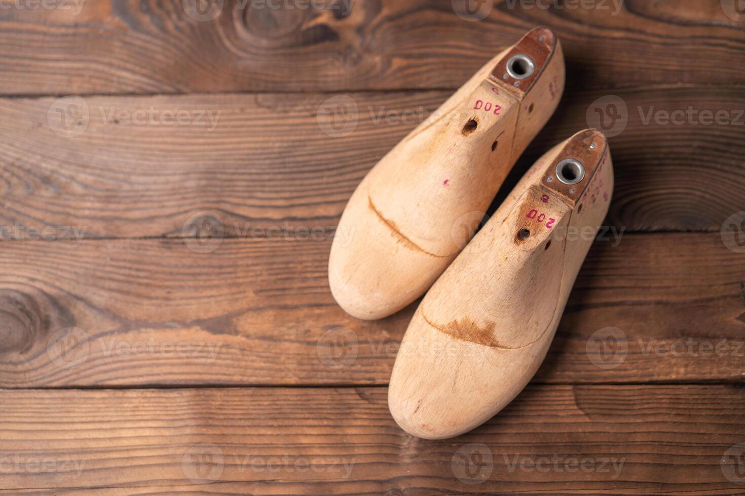 Leather samples for shoes and wooden shoe last on blue wooden table. photo