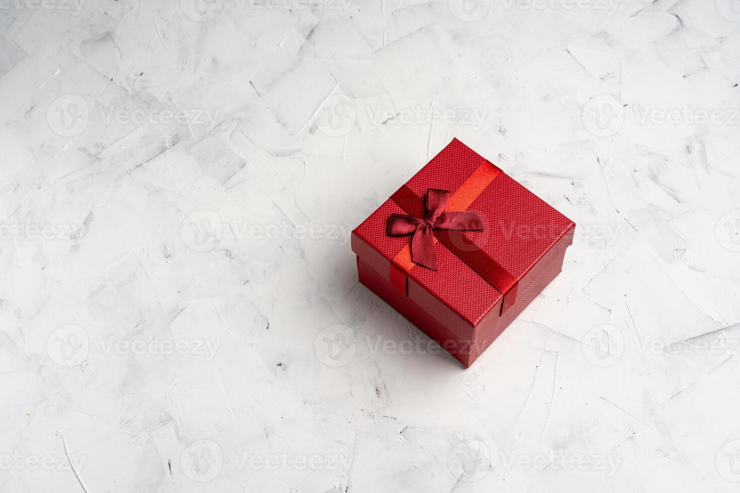 Red square holiday gift box against a white  background photo