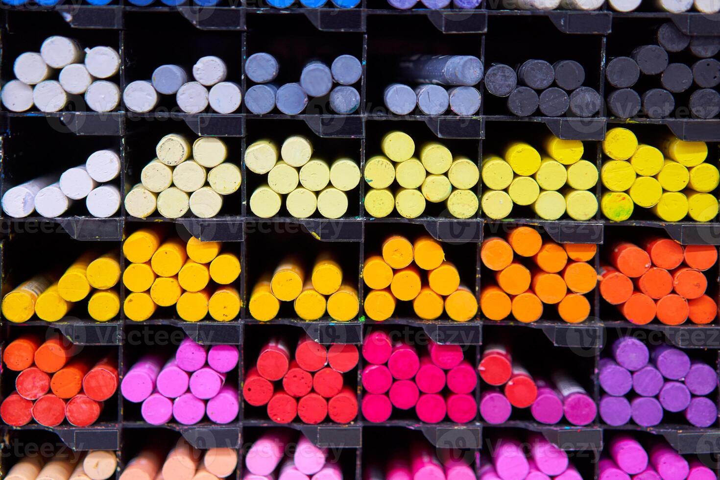 Multicolored pastel crayons art store in wooden cells photo