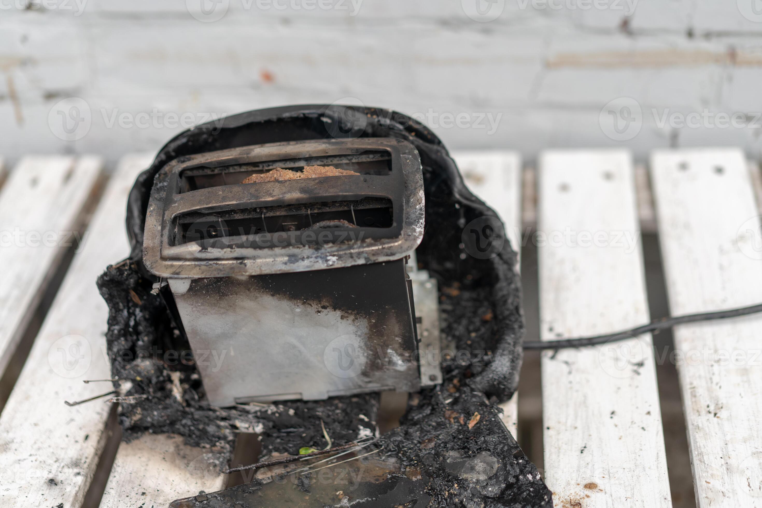 Burning toaster. Toaster with two slices of toast caught on fire over
