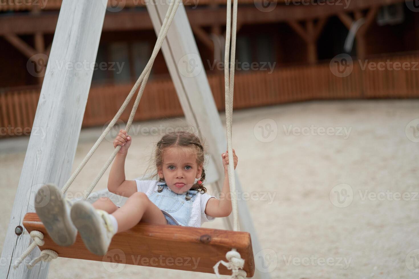 Playful kid swinging swing. Joyful little girl play having fun playground summertime photo