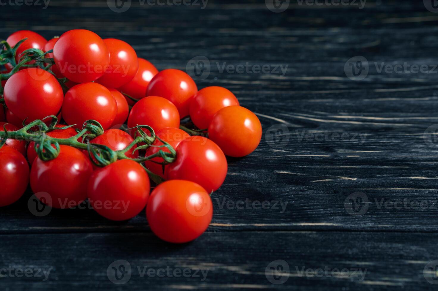 Cereza Tomates en el oscuro negro de madera mesa foto