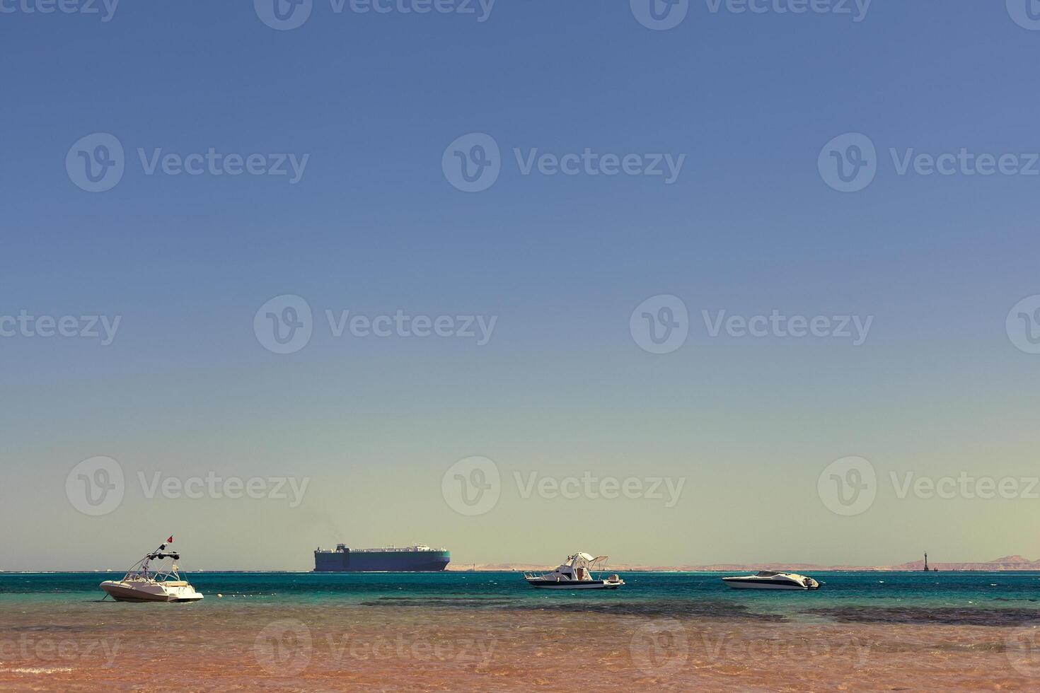 three yachts and a tanker in the sea bay photo