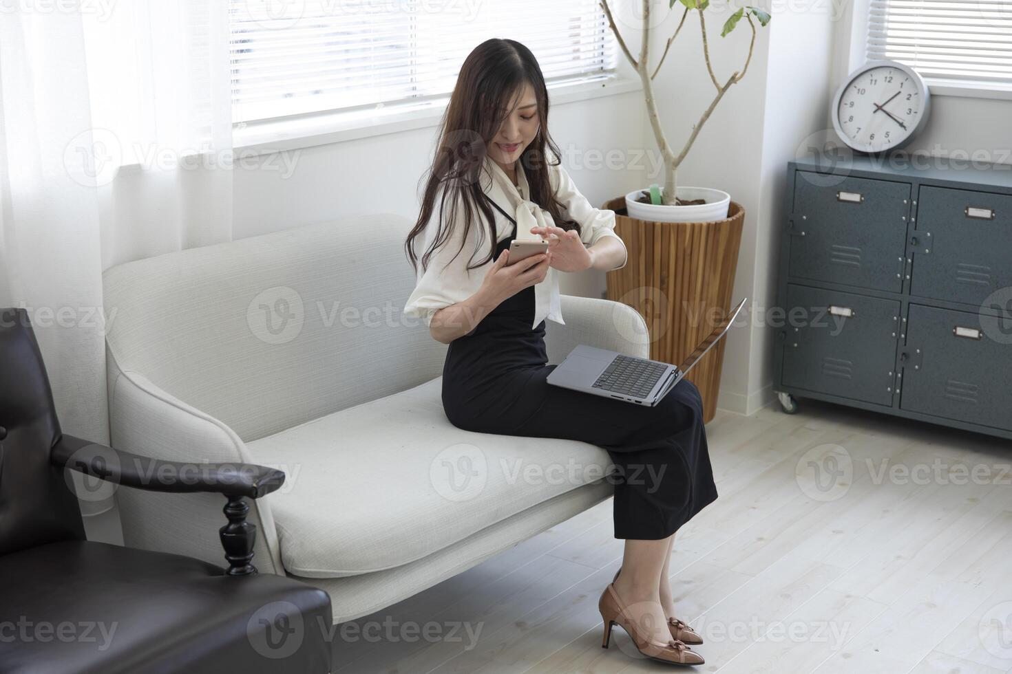 A Japanese woman checking smartphone by remote work in the home office photo