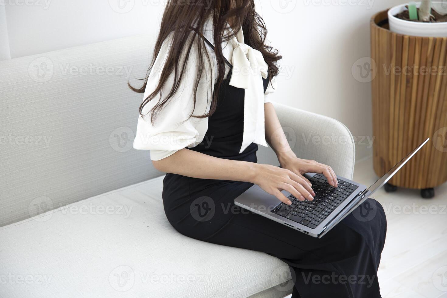 un japonés mujer mecanografía ordenador portátil por remoto trabajo en el oficina sin rostro composición foto