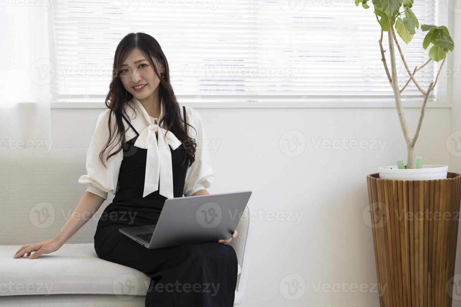 un japonés mujer comprobación teléfono inteligente por remoto trabajo en el hogar oficina foto