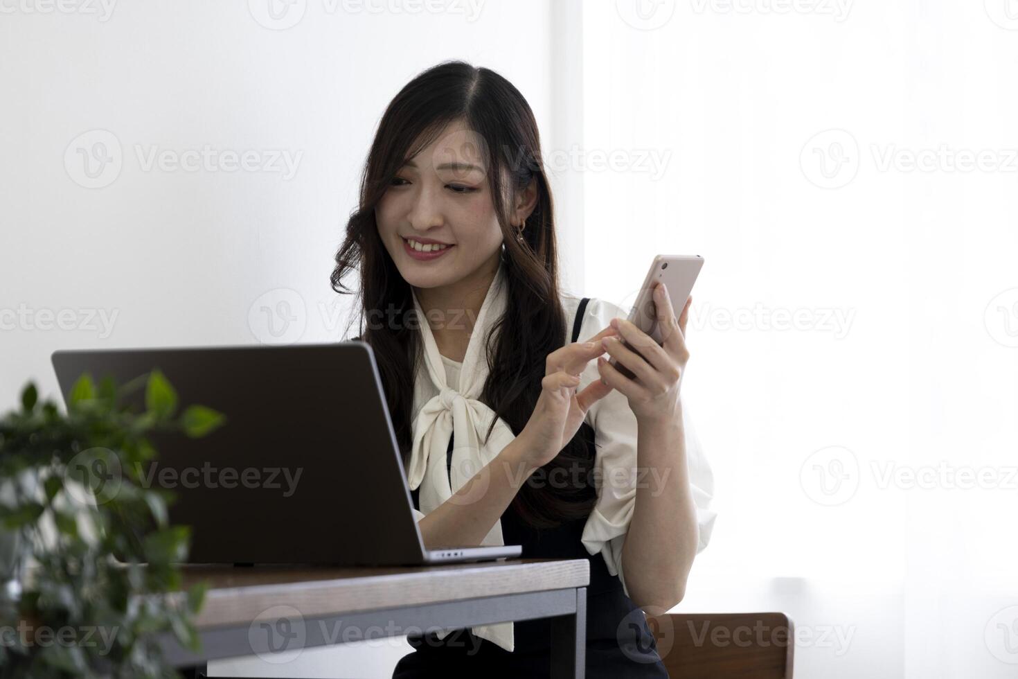 A Japanese woman checking smartphone by remote work in the small office photo