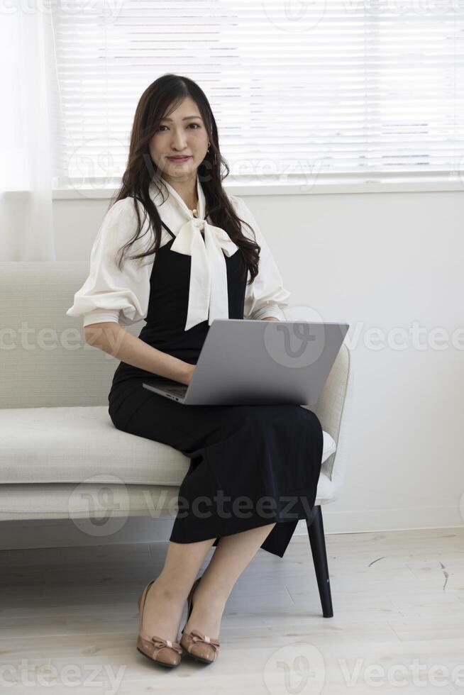 A Japanese woman checking smartphone by remote work in the home office photo