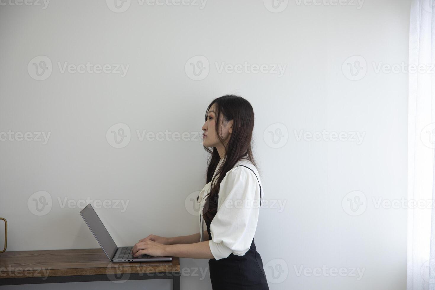 un japonés mujer comprobación teléfono inteligente por remoto trabajo en el hogar oficina foto