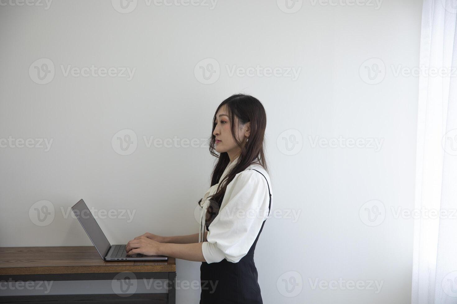 A Japanese woman checking smartphone by remote work in the home office photo