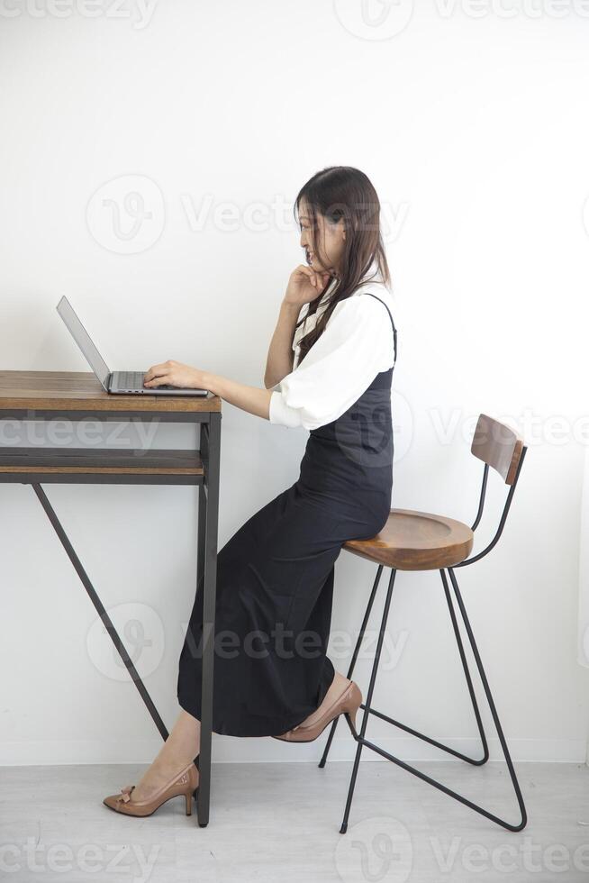 A Japanese woman checking smartphone by remote work in the home office photo