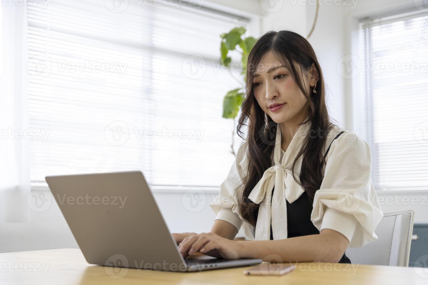 un trabajando japonés mujer por remoto trabajo en el hogar oficina de cerca foto