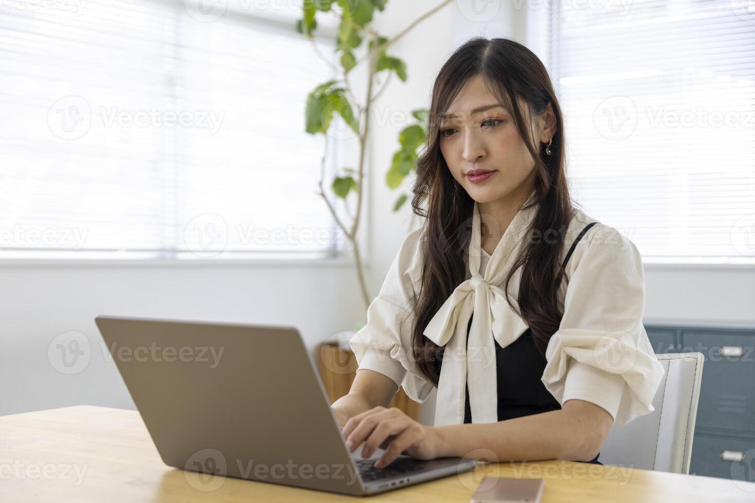 un trabajando japonés mujer por remoto trabajo en el hogar oficina de cerca foto