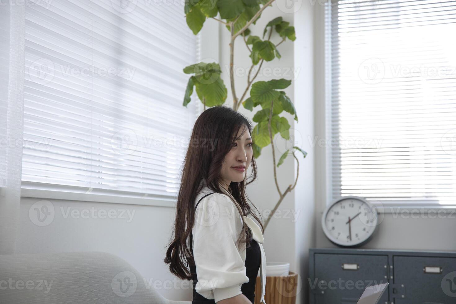 un trabajando japonés mujer por remoto trabajo en el hogar oficina de cerca foto