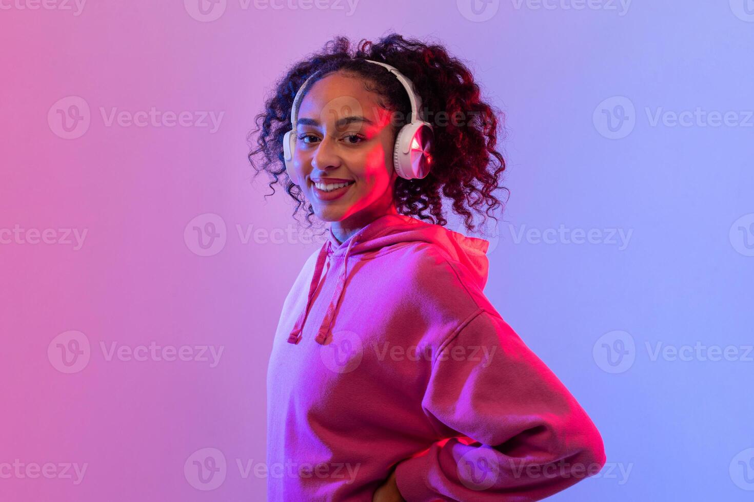 Confident black woman with headphones in neon light photo