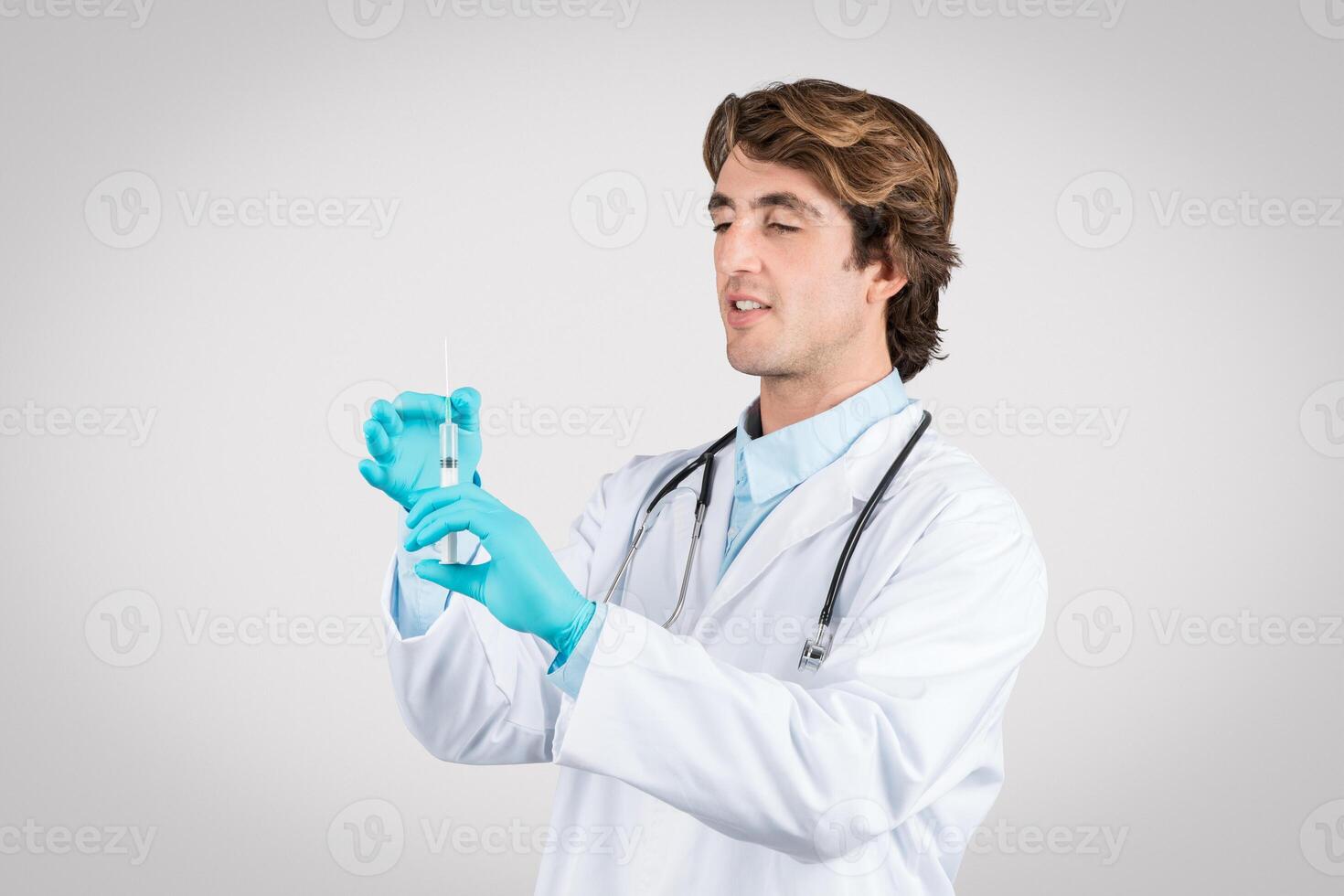 Doctor man preparing vaccine syringe carefully photo