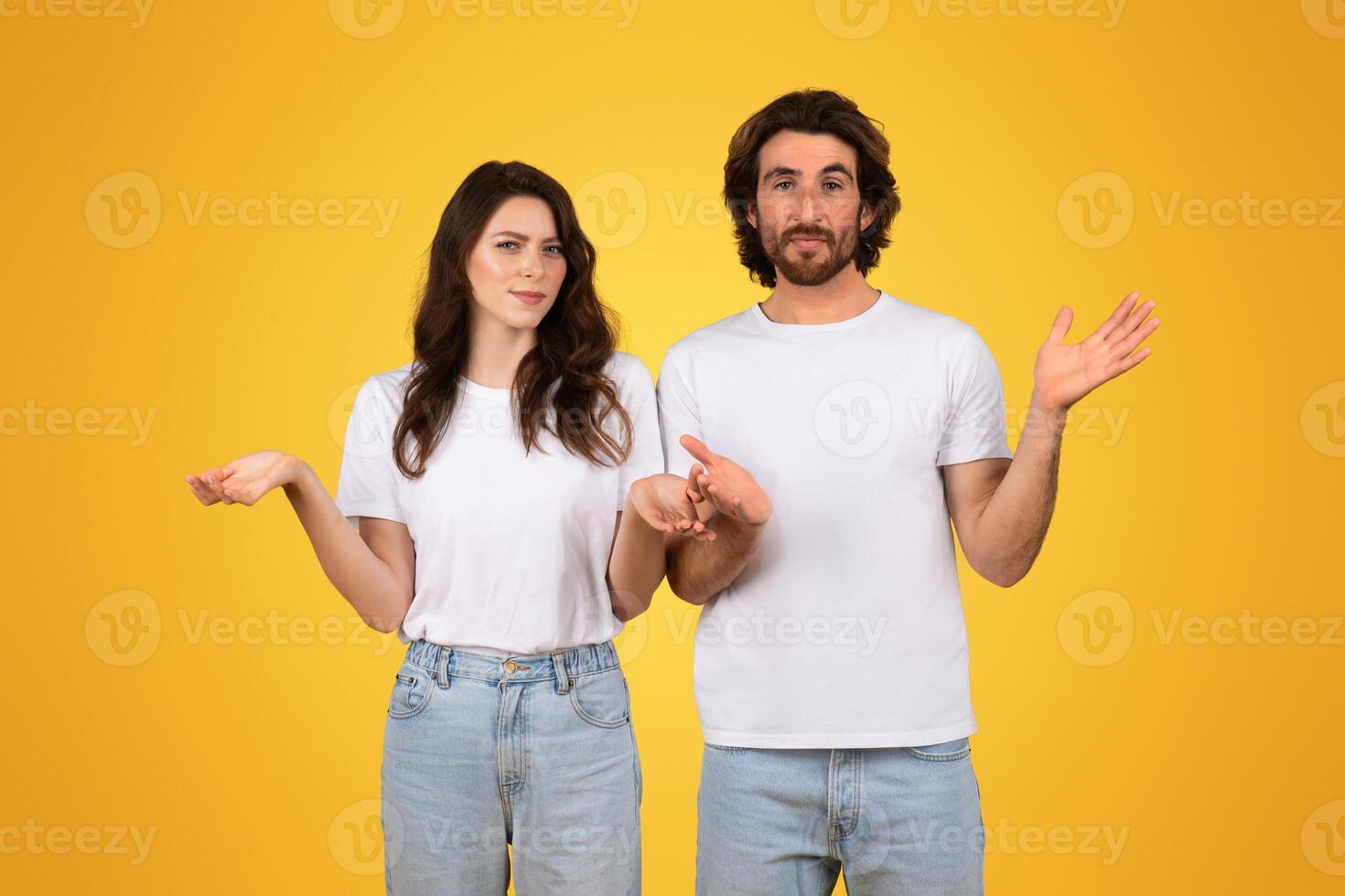 Confused young couple with raised hands, showing uncertainty and questioning gestures photo