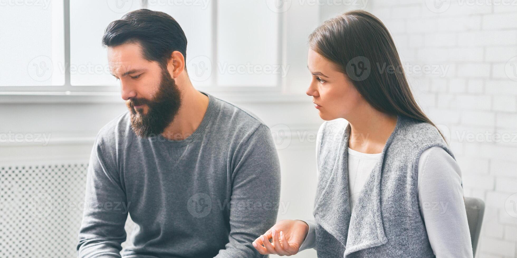 Disappointed wife blaming her depressed husband at marriage counselling session photo