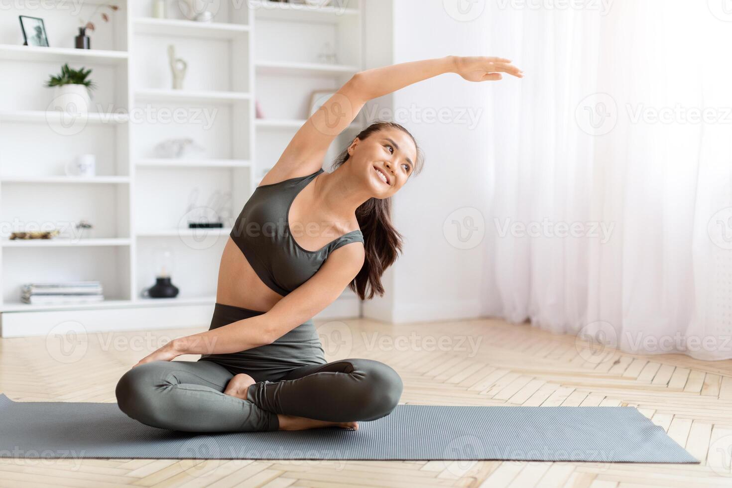 Portrait Of Beautiful Young Asian Female Doing Stretching At Home photo