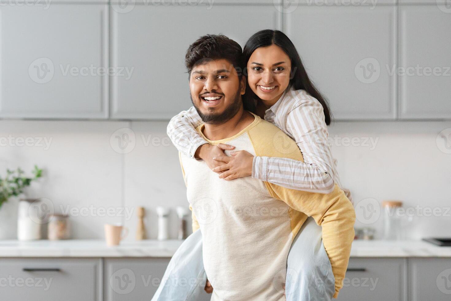 Cheery young eastern couple have fun at kitchen photo
