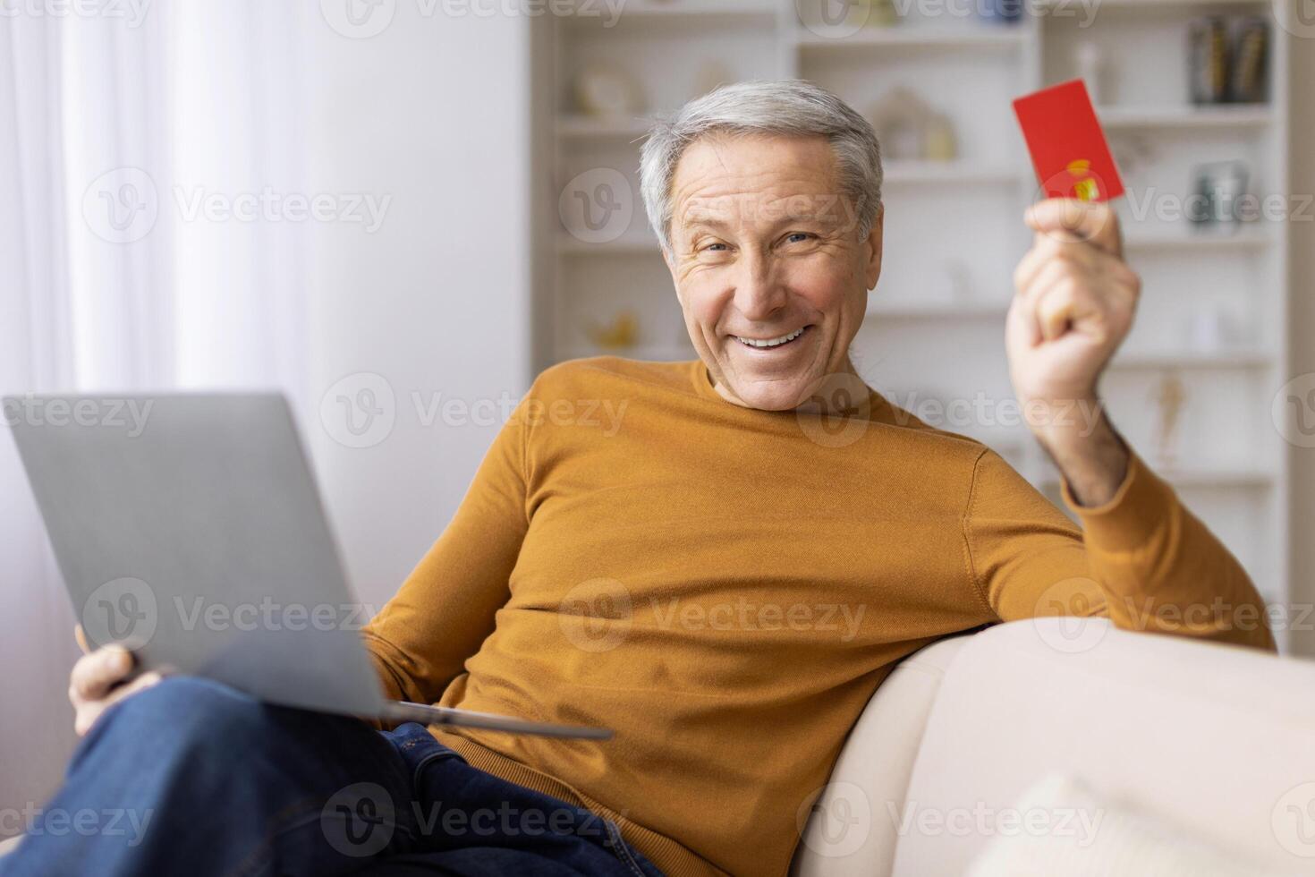 Older man with laptop and credit card ready to pay photo