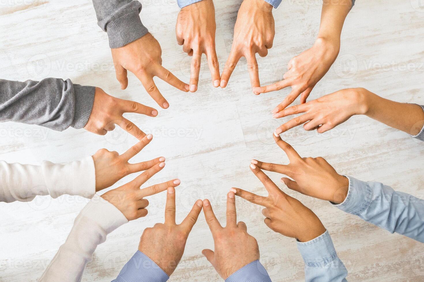 Group of hands showing peace hand sign, top view photo