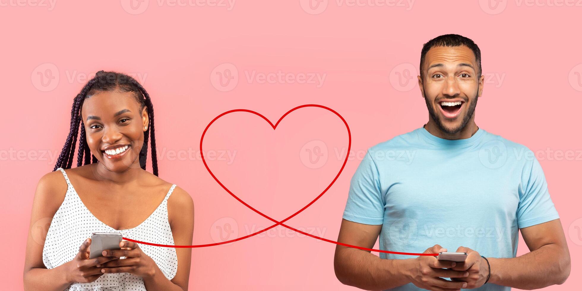 A delighted woman in a polka dot dress and an enthusiastic man in a blue t-shirt are holding smartphones photo