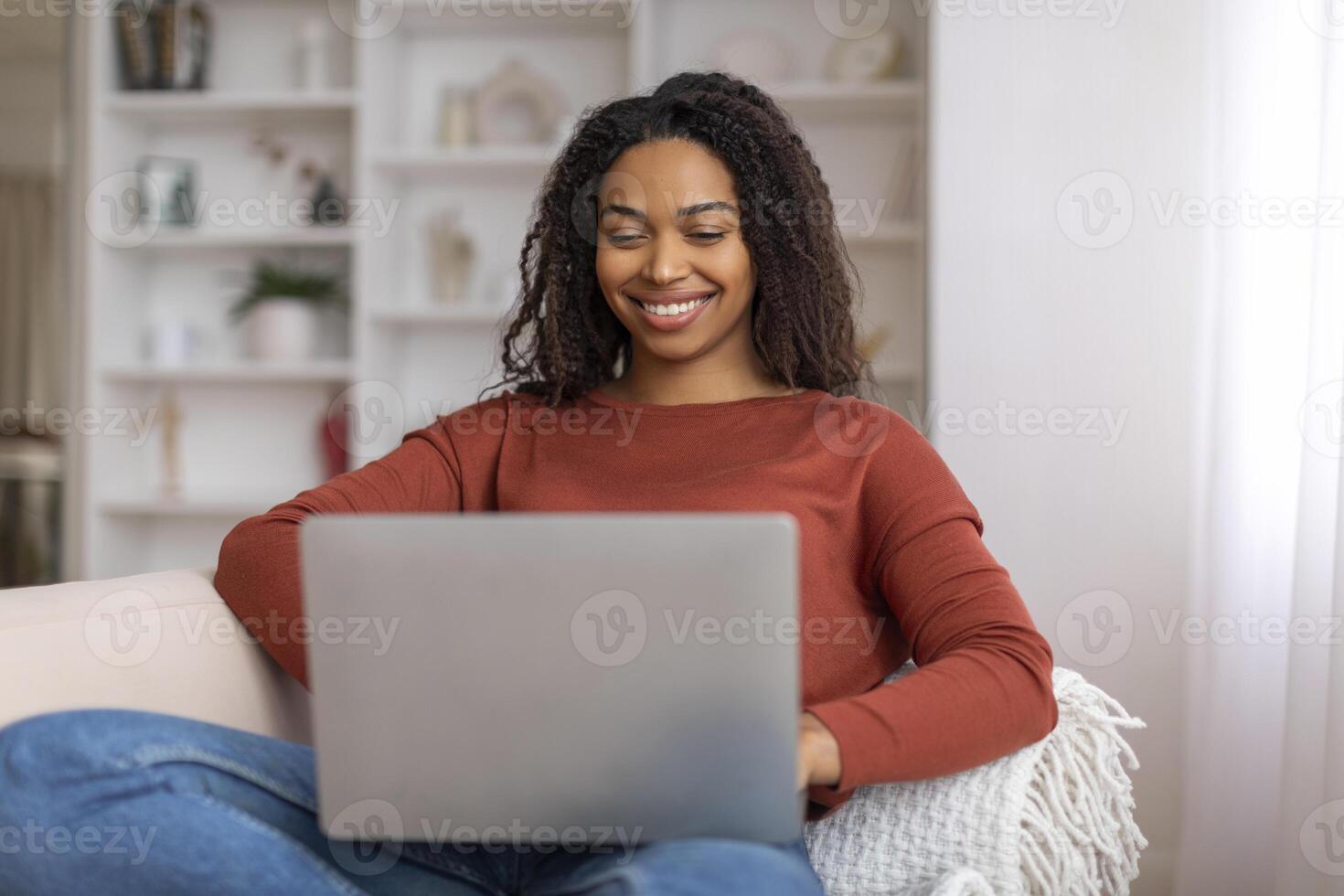 Relaxed black woman enjoying working from home, using her laptop computer photo