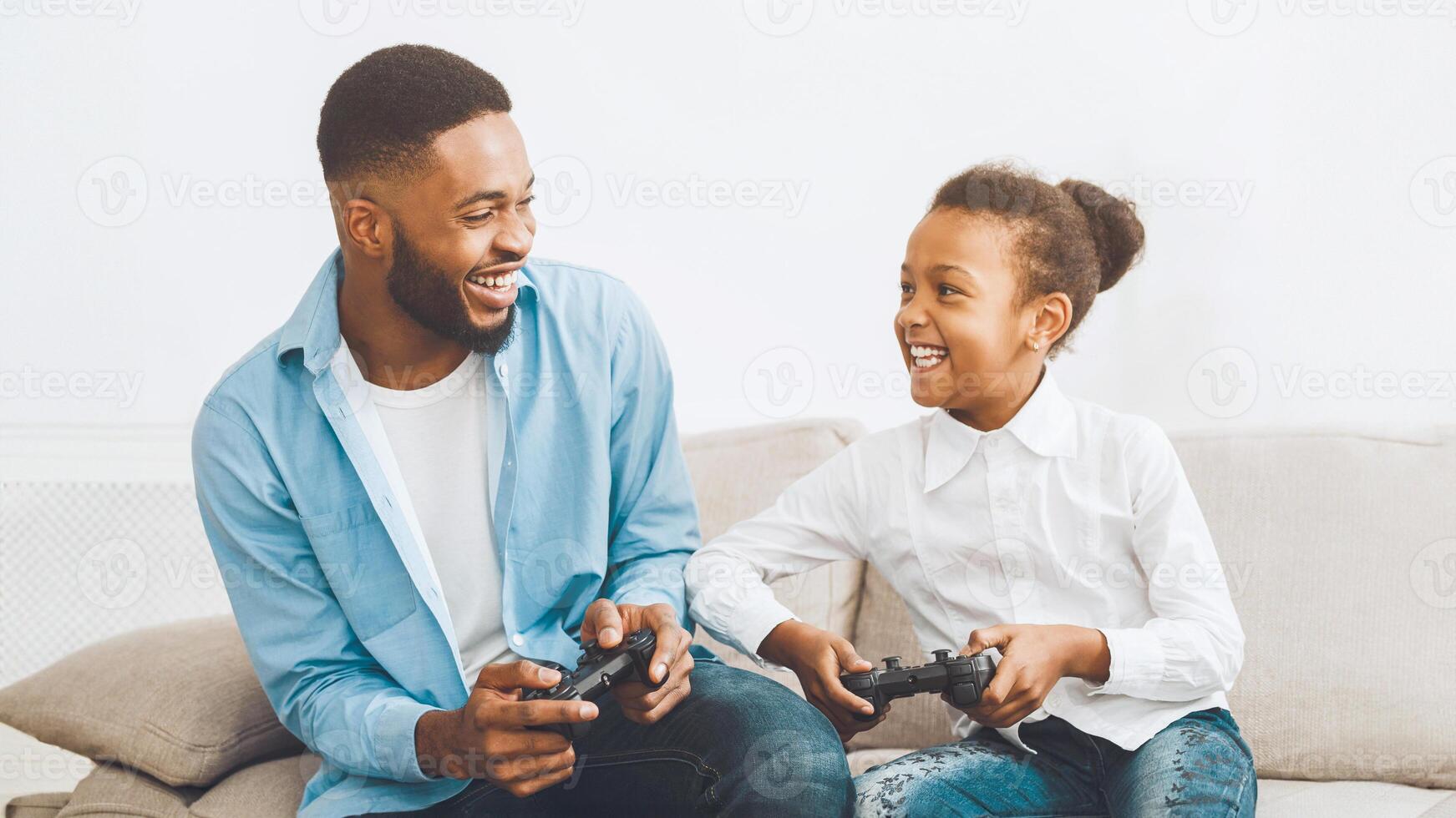 Happy father and daughter playing video game at home photo