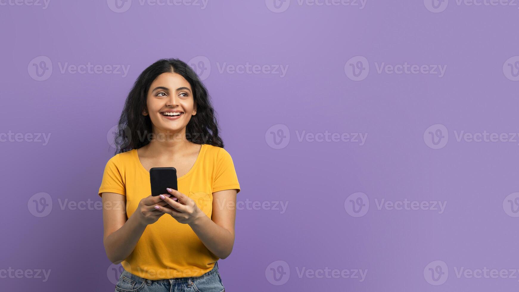 Happy woman texting on violet photo