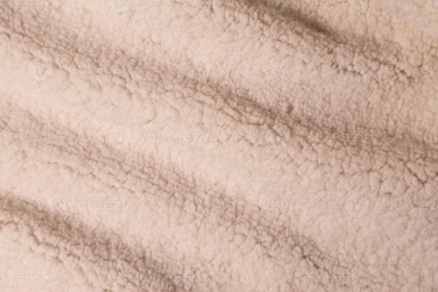 Top view of white soft sheepskin textile plaid. Warm cozy texture background photo