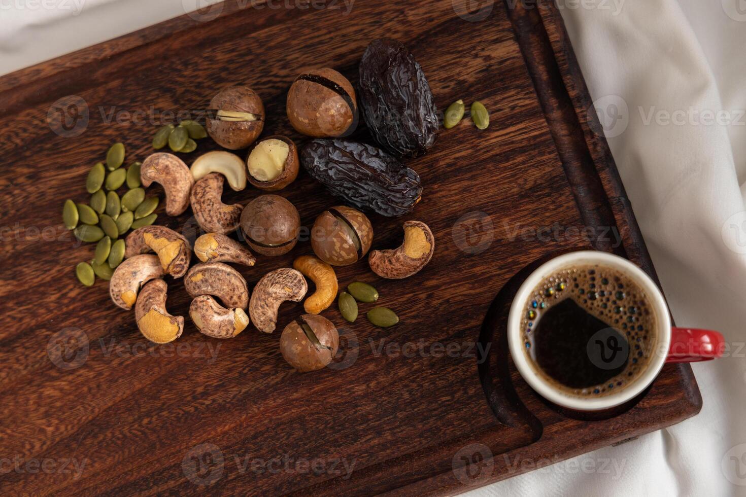 A tasty charcuterie board full of various nuts and coffee for breakfast. photo