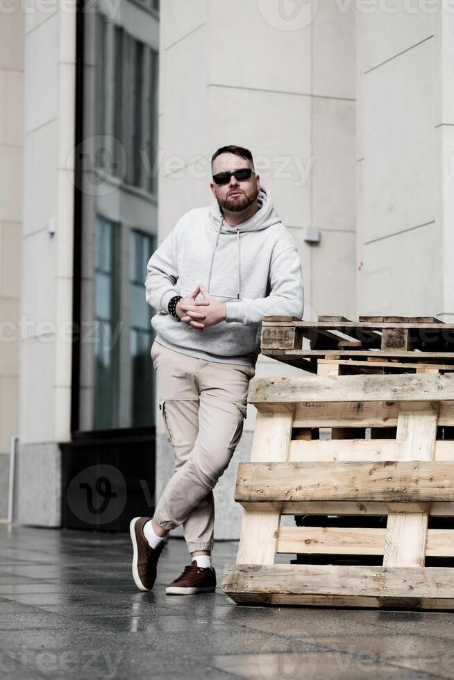 Handsome young man standing near wooden pallet photo