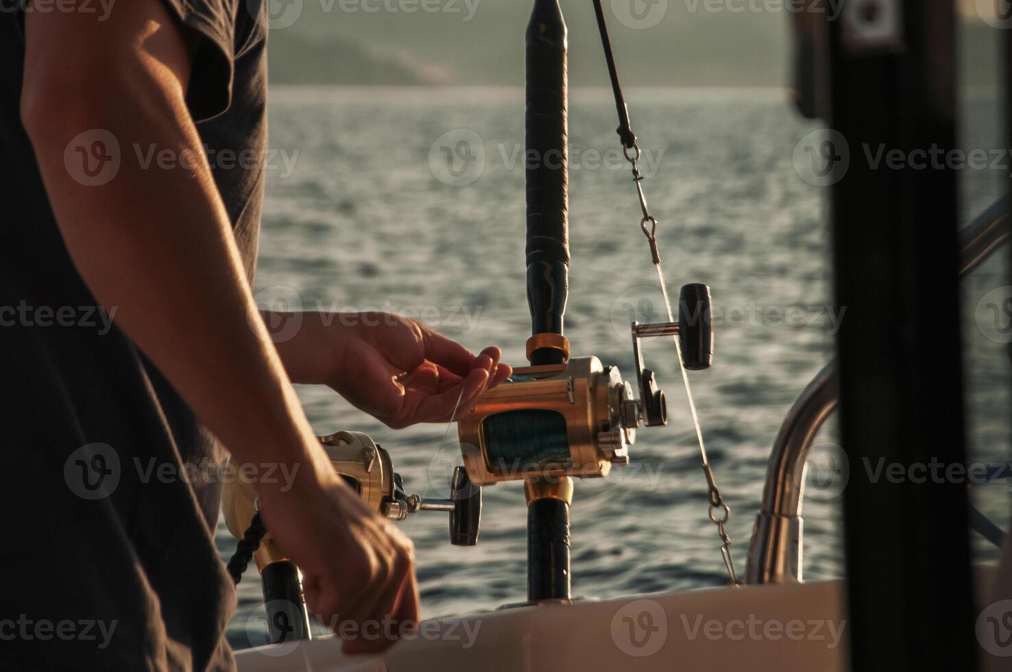 Men's hands with a spinning rod in sea fishing photo