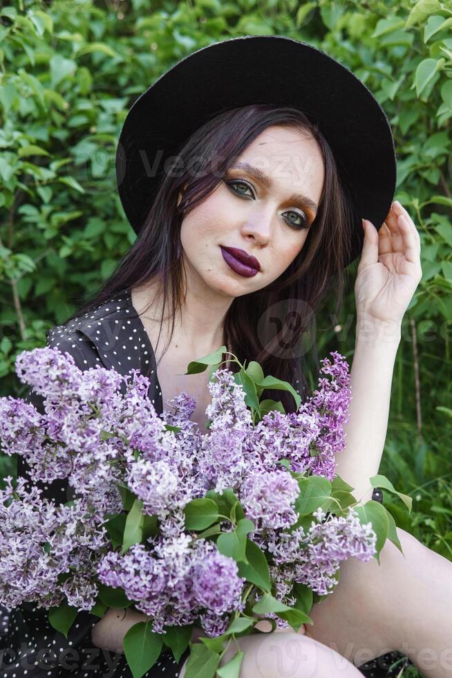 A fashionable girl with dark hair, a spring portrait in lilac tones in summer. Bright professional makeup. photo