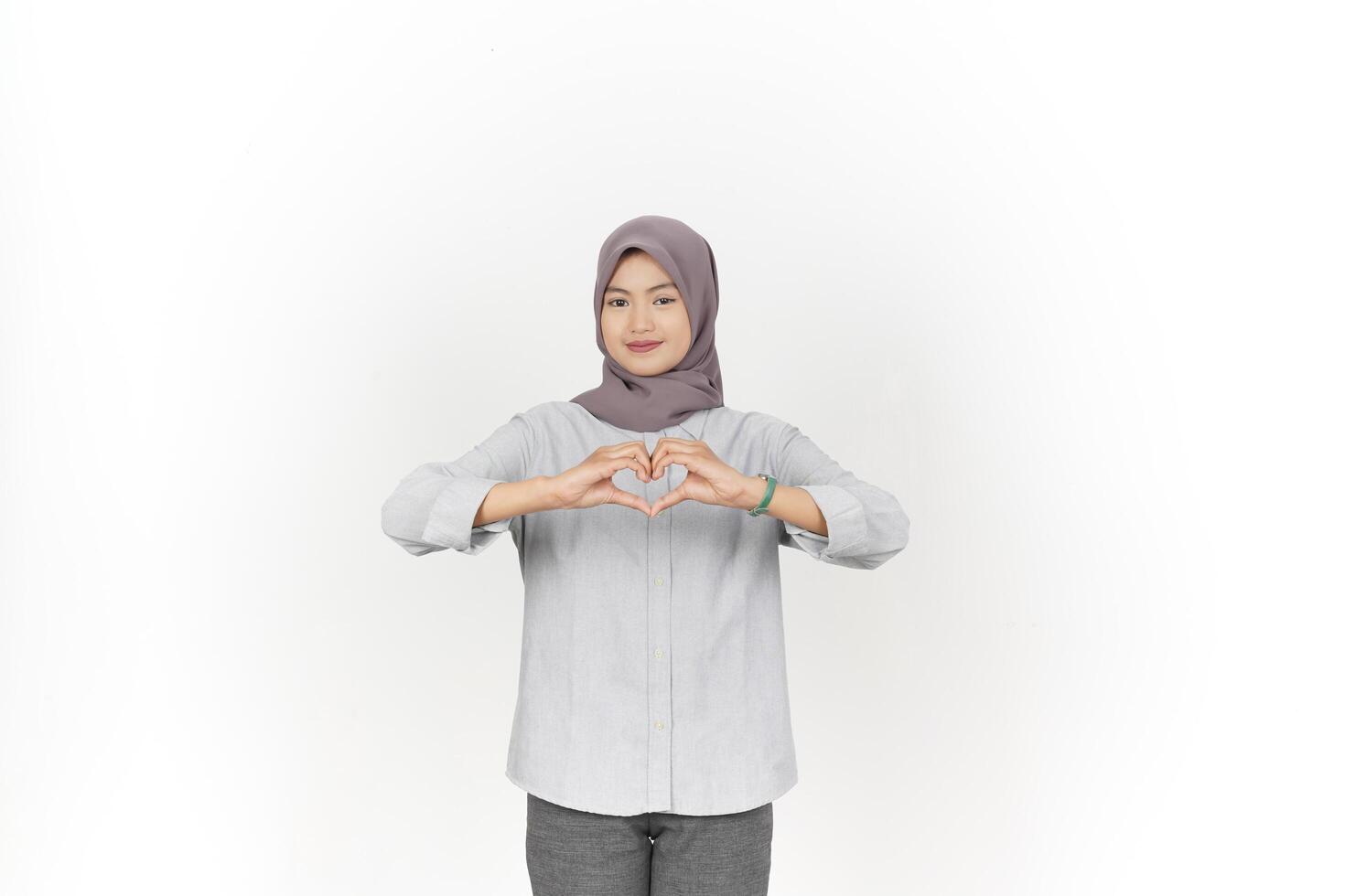 Young Asian woman wearing hijab showing love heart sign isolated on white background photo