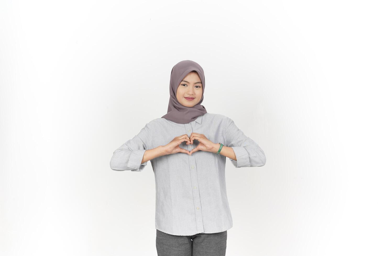 Young Asian woman wearing hijab showing love heart sign isolated on white background photo