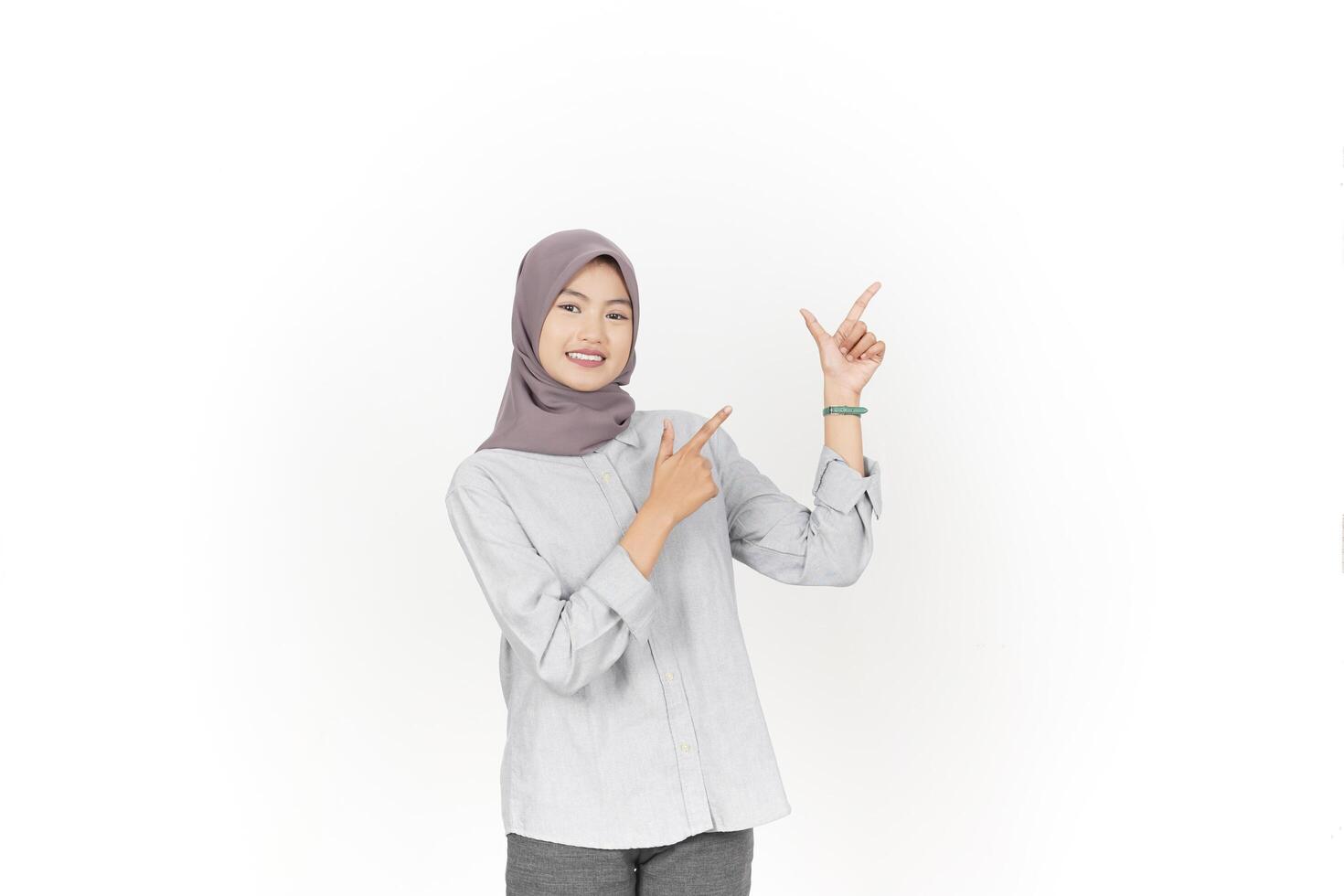 Young Asian woman wearing hijab Pointing side copy space isolated on white background photo