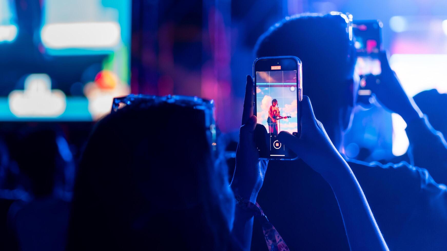 People holding smart phone and recording and photographing in concert , silhouette of hands with mobile , event background concept photo