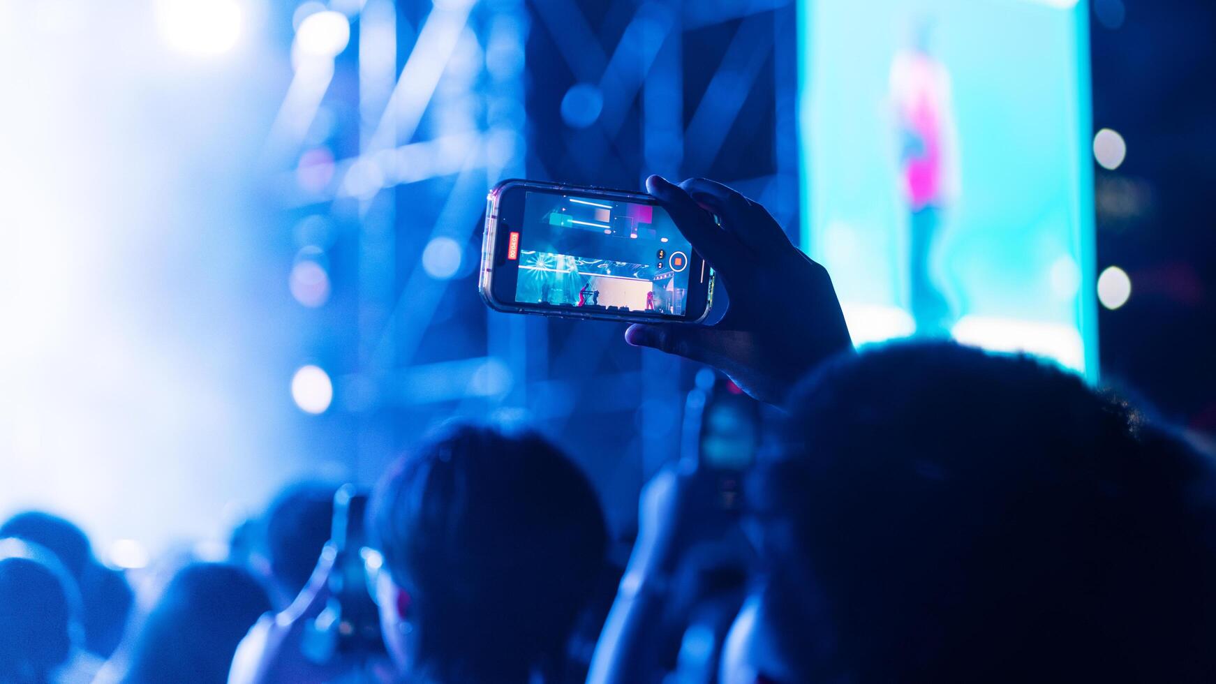 People holding smart phone and recording and photographing in concert , silhouette of hands with mobile , event background concept photo