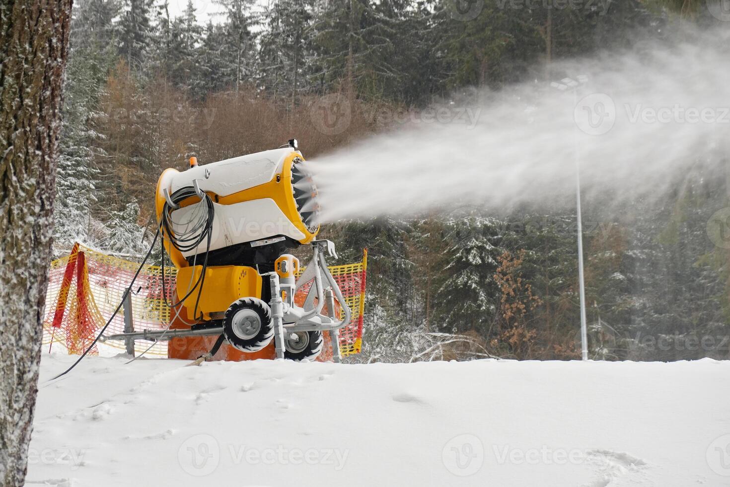 Snow cannon makes artificial snow. Snowmaking systems sprays water to produce snow. photo