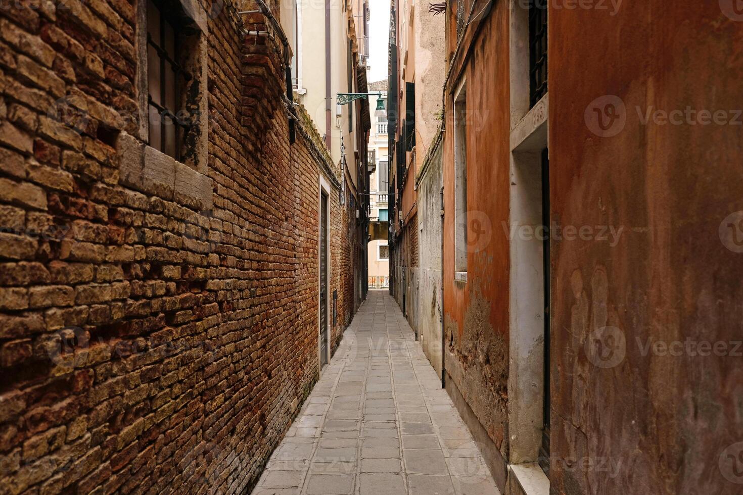 Typical narrow street with historical houses in Venice. Narrow pedestrian streets of Venice between the channels. photo