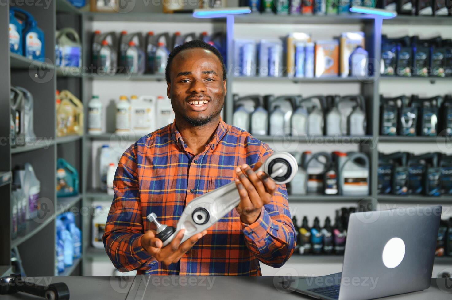 Portrait of a handsome african salesman in an auto parts store. The concept of car repair photo