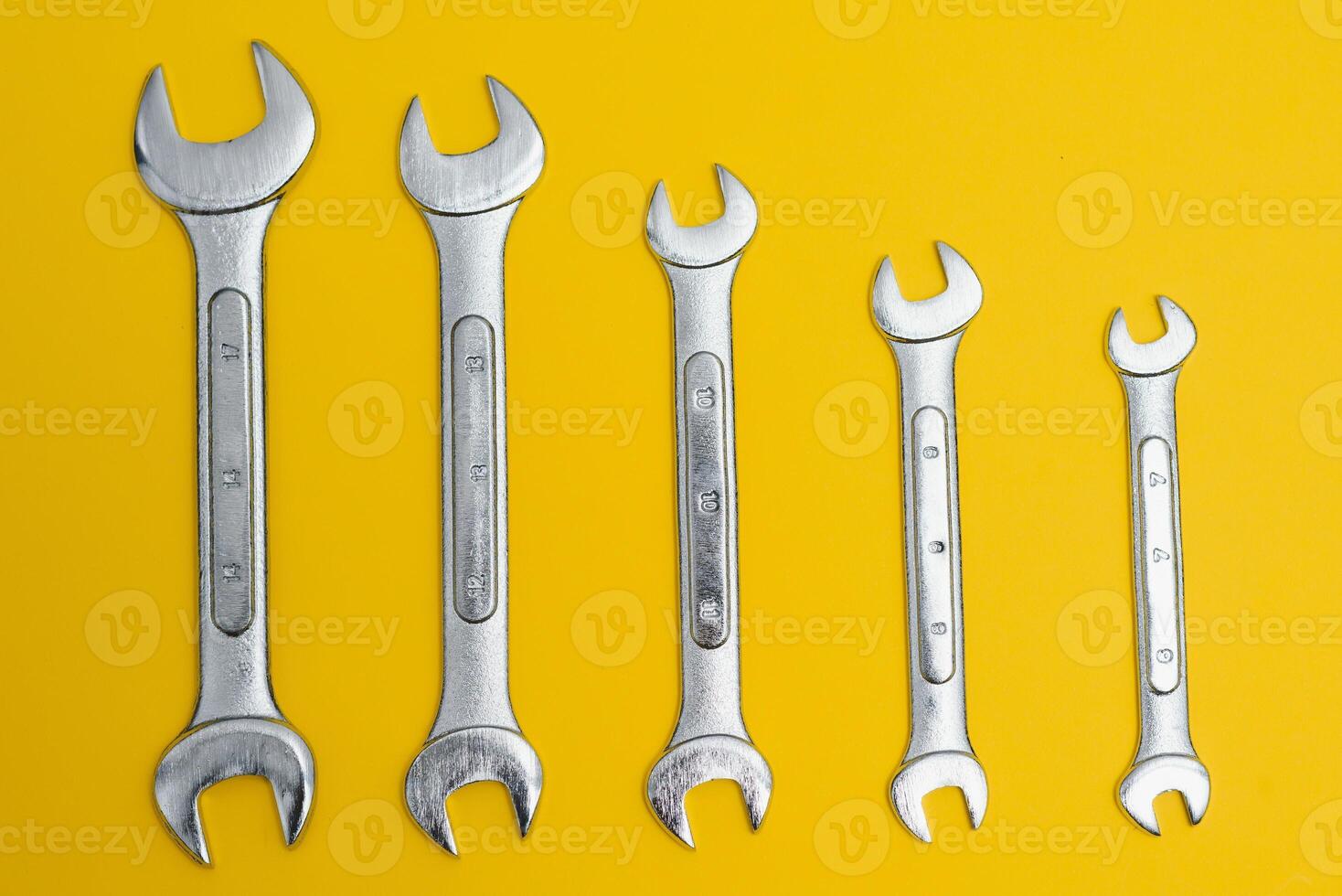 new wrenches on a yellow background. photo
