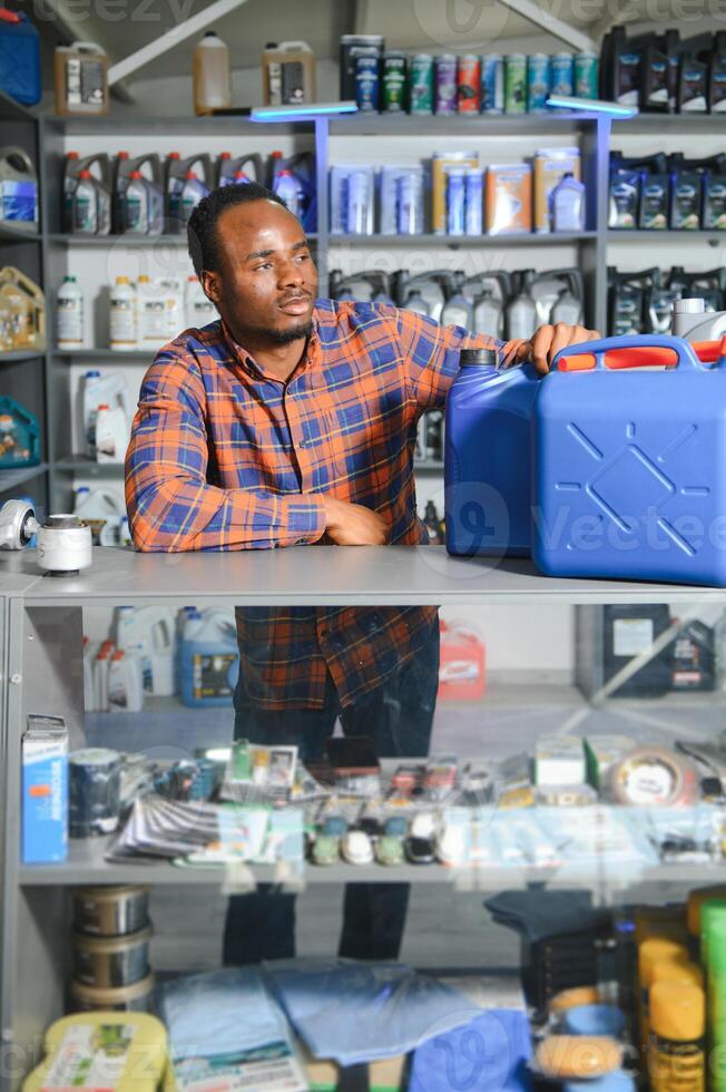 Portrait of a handsome african salesman in an auto parts store. The concept of car repair photo